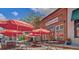 Outdoor seating at The Eclectic Chef restaurant, featuring red umbrellas and a charming brick building at 1300 S Main St, Summerville, SC 29483