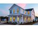 Charming two-story white home with a covered porch and beautiful architectural details at sunset at 1435 Clay Field Trl, Summerville, SC 29485