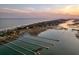 Expansive aerial view features docks and the waterway, with a tranquil beach in the background at 1504 Forrest Ave, Folly Beach, SC 29439