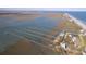 Panoramic aerial perspective of waterfront homes featuring private docks, with coastal beauty and water access at 1504 Forrest Ave, Folly Beach, SC 29439