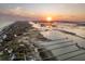 Dramatic aerial shot highlights a serene waterway, docks, and a breathtaking sunset backdrop at 1504 Forrest Ave, Folly Beach, SC 29439