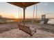 Relaxing backyard swing under a covered patio overlooks the waterway and dock at sunset at 1504 Forrest Ave, Folly Beach, SC 29439