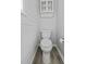 Small bathroom with a toilet, shiplap accent wall and a window for natural light at 1504 Forrest Ave, Folly Beach, SC 29439