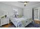 Cozy bedroom with a patterned comforter, natural light, and hardwood floors at 1504 Forrest Ave, Folly Beach, SC 29439