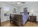 Cozy bedroom with warm wood floors, a queen-size bed, and windows with views at 1504 Forrest Ave, Folly Beach, SC 29439