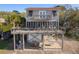 Charming coastal home elevated on stilts, featuring a spacious deck perfect for outdoor entertaining at 1504 Forrest Ave, Folly Beach, SC 29439