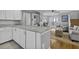 Bright kitchen adjacent to the living room, features ample counter space, white cabinetry and hardwood floors at 1504 Forrest Ave, Folly Beach, SC 29439