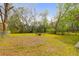 Expansive backyard with lush lawn, mature trees, and a cozy seating area at 1617 Balsam St, Charleston, SC 29407