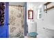 Bright bathroom features a white vanity, decorative mirror, and a nautical-themed shower curtain at 1617 Balsam St, Charleston, SC 29407