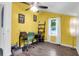 Sunny bedroom features a ceiling fan, a bright yellow accent wall, and hardwood-style floors at 1617 Balsam St, Charleston, SC 29407