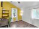 Bright bedroom with yellow accent wall, modern lighting, wood floors, and two windows for ample natural light at 1617 Balsam St, Charleston, SC 29407