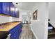 Galley kitchen with blue cabinets, colorful tile countertops, and stainless appliances leading to an adjacent dining area at 1617 Balsam St, Charleston, SC 29407