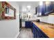 Bright kitchen features blue cabinets, colorful tile countertops, stainless steel refrigerator, and modern light fixture at 1617 Balsam St, Charleston, SC 29407