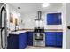 Bright kitchen featuring blue cabinets, stainless steel appliances, colorful tiled countertops, and a modern range hood at 1617 Balsam St, Charleston, SC 29407