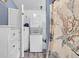 Laundry area with stacked washer and dryer, decorative folding screen, and ample storage space at 1617 Balsam St, Charleston, SC 29407