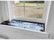 Window decorated with mosaic tiles overlooks a grassy yard and outdoor furniture at 1617 Balsam St, Charleston, SC 29407