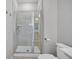 Tiled walk-in shower featuring glass door, neutral tile, shower head and convenient shelving at 1675 Indy Dr, North Charleston, SC 29405