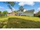 Large backyard with a wooden playset and a house with a rear patio and a fenced yard at 184 Ponderosa Dr, Ladson, SC 29456
