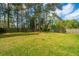 Expansive backyard showcasing a wooden playset, tall trees, and a secure fence at 184 Ponderosa Dr, Ladson, SC 29456
