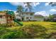 Green backyard with a wooden playset and a house with rear entrance and fenced in yard at 184 Ponderosa Dr, Ladson, SC 29456