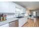 Eat-in kitchen with stainless dishwasher, white cabinetry, subway tile, granite countertop, and wood floor at 184 Ponderosa Dr, Ladson, SC 29456