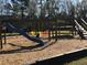 Community playground features a slide, swings, and wooden climbing structure on a mulch surface, creating a fun play area at 184 Ponderosa Dr, Ladson, SC 29456