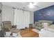 Bedroom featuring hardwood floors, a gray chair, and a crib with blue accent wall at 2107 Military Way, Charleston, SC 29414