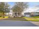 Attractive two-story home with front porch and a detached garage with a basketball hoop, surrounded by green lawns at 2107 Military Way, Charleston, SC 29414