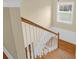Staircase with hardwood steps, white banister, and natural light from nearby window at 2107 Military Way, Charleston, SC 29414