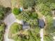 Aerial view of a home nestled among mature trees, featuring a pool, and a long driveway at 220 New Oak Ln, Moncks Corner, SC 29461