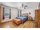 Cozy bedroom with hardwood floors, a wood-framed bed with blue comforter, and ample natural light from the windows at 220 New Oak Ln, Moncks Corner, SC 29461