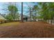 Large fenced backyard with mature trees, a patio seating area and a screened-in porch at 234 Lipman St, Summerville, SC 29483