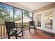 Relaxing screened porch with wood flooring, chairs, and view of the wooded backyard at 234 Lipman St, Summerville, SC 29483