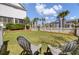 Landscaped backyard with lawn and a pair of plastic lounge chairs, with view of neighboring houses at 2681 Park West Blvd, Mount Pleasant, SC 29466