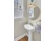 Charming pedestal sink with gold mirror and fixtures in a well-lit powder room at 2681 Park West Blvd, Mount Pleasant, SC 29466