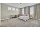 Bright carpeted bedroom with a large bed, three windows, storage and neutral decor at 2681 Park West Blvd, Mount Pleasant, SC 29466