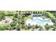 Aerial view of a community pool surrounded by lush greenery, sun loungers, and umbrellas for relaxation at 2681 Park West Blvd, Mount Pleasant, SC 29466