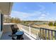 Outdoor balcony with rocking chairs offers serene waterfront views of the marsh and pier at 27 Waterway Island Dr, Isle of Palms, SC 29451