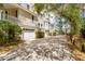 Exterior view showcasing the home, a paved driveway, garage, and mature trees at 27 Waterway Island Dr, Isle of Palms, SC 29451