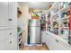 Walk-in pantry provides ample storage with built-in shelves and a refrigerator for organization at 27 Waterway Island Dr, Isle of Palms, SC 29451