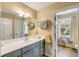 A well-lit bathroom featuring a large vanity, plenty of storage, and a view to the outside at 28 Rebellion Rd, Charleston, SC 29407