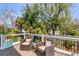Deck with cushioned wicker seating, a small glass-topped table, and lush greenery at 28 Rebellion Rd, Charleston, SC 29407