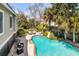 Aerial view of a backyard pool with lounging areas, landscaping, and mature trees at 28 Rebellion Rd, Charleston, SC 29407