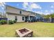 Expansive backyard featuring a fire pit, a well-maintained lawn, and a covered porch connected to the house at 2830 Backman St, Mount Pleasant, SC 29466