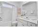 Bright bathroom with a white single sink vanity, bathtub and shower combo, and decorative flowers at 2830 Backman St, Mount Pleasant, SC 29466
