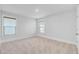 A bright bedroom featuring neutral walls, carpet, two windows with blinds, and a white door at 2830 Backman St, Mount Pleasant, SC 29466
