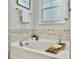 Relaxing bathroom featuring a soaking tub with a wooden tray and tiled walls at 2901 Backman St, Mount Pleasant, SC 29466