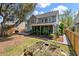 View of back of home with a sunroom, wood deck, manicured lawn, and garden beds at 2940 Amberhill Way, Charleston, SC 29414