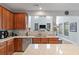 Modern kitchen showcasing wood cabinets, granite countertops, stainless appliances, and an open view to the living space at 2940 Amberhill Way, Charleston, SC 29414
