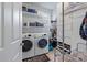 Spacious laundry room with washer, dryer, storage shelves, and tiled floor at 2940 Amberhill Way, Charleston, SC 29414
